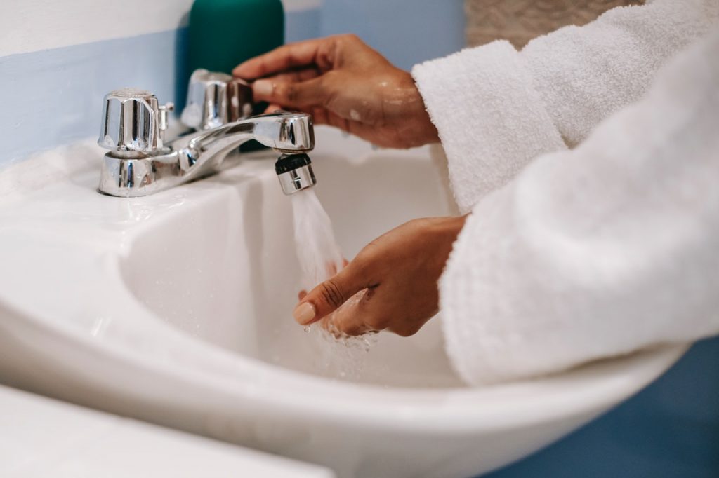 Femme se lavant les mains, portant un peignoir